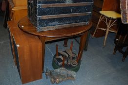 An Edwardian mahogany oval dining table being raised on square tapered legs with spade feet