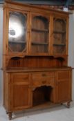 A large early 20th century country pine welsh dresser. The bun feet with drawers and cupboards to