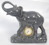 A 1950`s ceramic figurine of a large grey elephant having an inset gilt sunburst faced timepiece