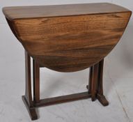 An Ercol beech and Elm `Golden Dawn` drop leaf dining / occasional table. Shaped supports having