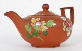 A Wedgwood terracotta / clay hand painted teapot with foliate decoration and lid.