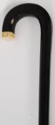 A good early 20th century ebony tapered walking stick having an ivory set knop to the arched