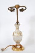 An Edwardian Bohemian glass table lamp with tubular brass metal fixtures, the cut glass enamel