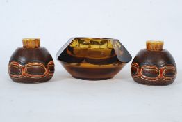 A pair of retro stoneware candle sticks along with a large smoked glass ashtray