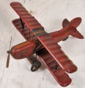 A 20th century large scale carved wooden model of a bi-plane with metal spinning propellar and