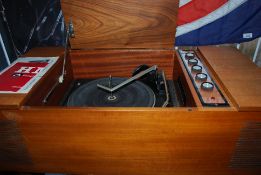 A vintage HMV radiogram with a Garrard deck standing on tapered legs.