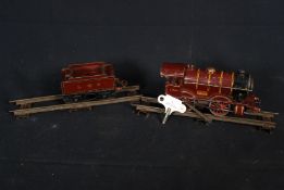 A Hornby clockwork 0 gauge LMS train complete with tender and track along with wind up key