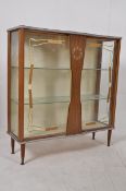 A 1970's formica display cabinet having faux clock centre, raised on turned supports.