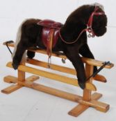 A good rocking horse complete with saddle in the antique style, sat on a pine swing base.