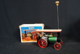 A Mamod steam engine tractor complete in the original box along with steering attachment etc