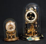 A pair of German mechanical anniversary clocks in glass domes being 400 Day with instructions, the
