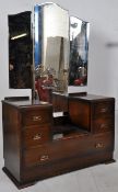 A 1930's Art Deco oak drop centre dressing table. The large swing mirror falling to the centre of