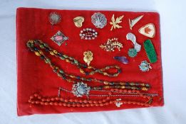 A quantity of costume brooches and necklaces on a jewellery display board to include yacht brooch,