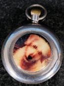 A silver pocket watch with enamel plaque of a dog