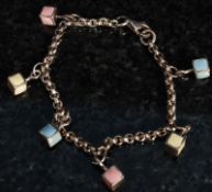 A childs silver charm bracelet with attached charms in varying colour in a cuboid form.