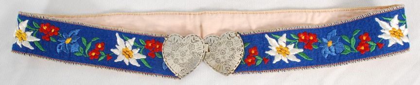 A Chinese silver chase decorated ladies belt with hand embroidered fabric. 77cm wide.