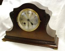 A mahogany cased mantel clock with scroll decoration striking on a gong.