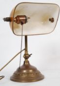 A brass bankers desk lamp having a smoke effect glass shade.