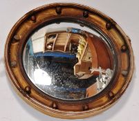 A decorative 20th century gilded porthole mirror with a decorative circular surround.