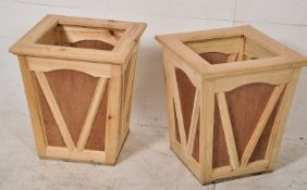 A pair of contemporary wooden planters having panelled sides with chamfered applied angular