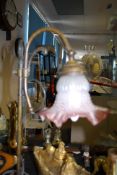 An Edwardian style brass table lamp complete with a frosted glass shade having cranberry coloured