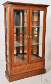 A contemporary glass display cabinet. Plinth base with drawer having glazed cabinet above with inset