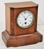 A late 19th century French oak cased mantle clock. The white enamel face set within oak case. The