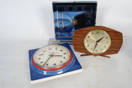 A 1980's blue ceramic wall clock with quartz movement together with another mirror backed clock