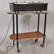 A 1970's retro butlers tea trolley on ebonised supports together with a hostess hot plate serving