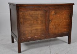 A 1930's Oak blanket box chest raised on square legs. The hinged lid atop over open storage with the