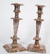 A pair of silver plate on copper Rococo style candle sticks.