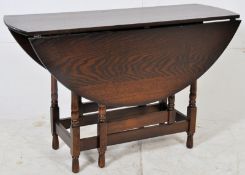 A Georgian style country oak wood drop leaf / gate leg dining table. Raised on turned legs united by