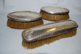 A set of 3 American sterling silver clothes brushes by Foster & Bailey. The 3 stamped sterling
