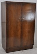 A 1930's Art Deco oak tallboy / bachelors wardrobe. Inset plinth base with fitted interior having