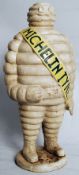 A large painted cast iron Michelin man / Bibendum, Yellow ribbon with notation  ' Michelin ' Sourced