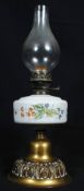 An early 20th century oil lamp with milk glass reservoir and hand painted decoration with glass flue