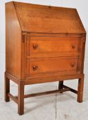 A 20th century Gordon Russell style oak bureau. Raised on squared supports having a chest of drawers