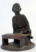 A heavy early 20th century bronze Japanese scholar / young seated girl at desk