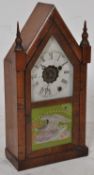 A late 19th century American walnut spire cased gingerbread clock by the Ansonia Clock Co., New