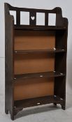 A 1920's carved oak arts and crafts revival bookcase. Shaped and pierced supports having central