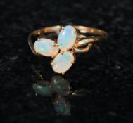 A ladies 9ct gold 3 stone opal ring set on a decorative shaped gold hoop, The 3 opal stones set