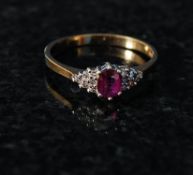 A 9ct gold ladies ruby and diamond ring. The centre set ruby surrounded by diamonds