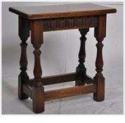 A 20th century carved oak Jacobean revival joint stool. Raised on turned legs united by stretchers