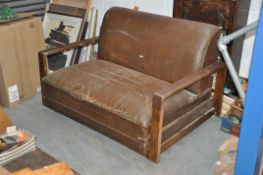 A 1930`s Art Deco faux leather sofa bed / couch settee. The angular show wood arms set either side