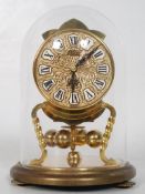 A Kundo German anniversary clock with mechanical movement encased in a glass dome. 16cm tall.