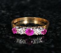 An 18ct gold ladies ruby and diamond ring. The 3 ruby stones set to a diamond channel and within a