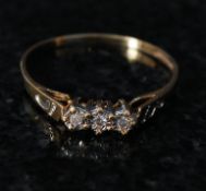 A 9ct gold 3 stone diamond ring. The 3 stones set on bevel mounts with the hoop chase engraved with