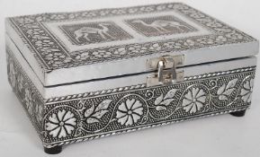 An Indian silver trinket box. The silver raised in relief having decorative camel and foliate