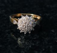 A 9ct gold ladies diamond cluster ring. The illusion set diamounds mounted to a plain gold hoop