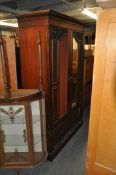 A Victorian 19th century mahogany twin door upright wadrobe armoire. The twin mirror doors (one